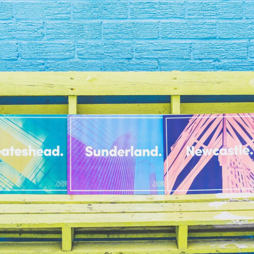 Three colourful posters from the Alternative Futures exhibition design by Swaddle Creative on a blue background